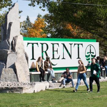 Students sitting by the Trent Sign.
