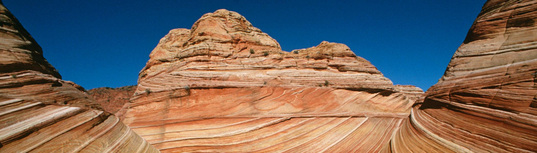 Brown rock formations in the desert against a blue sky