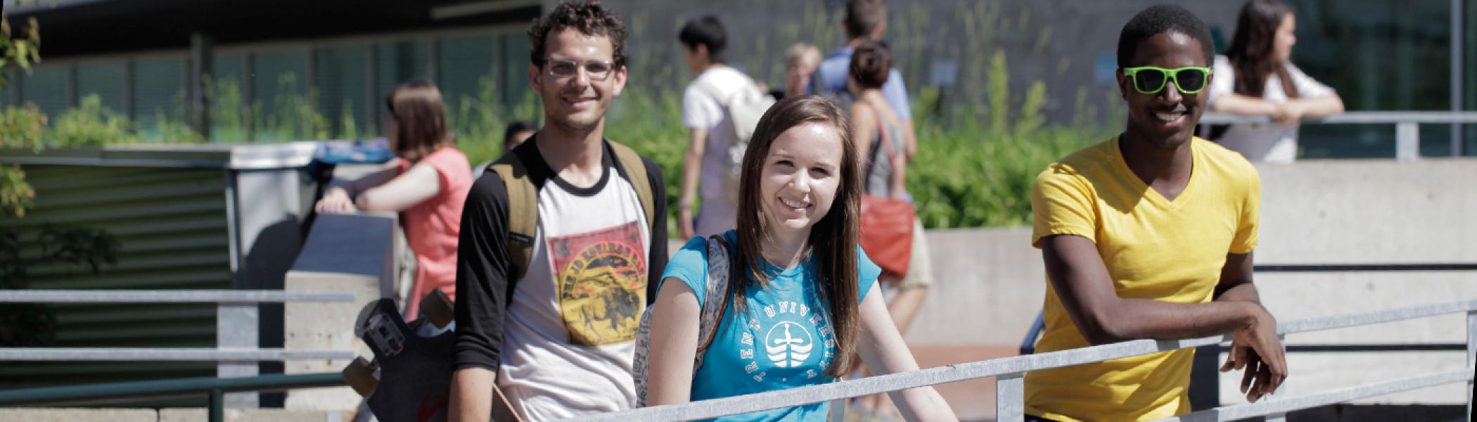 Students standing at the railing of faryon bridge near gzowski college in the early afternnon