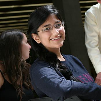 Student with glasses smiling