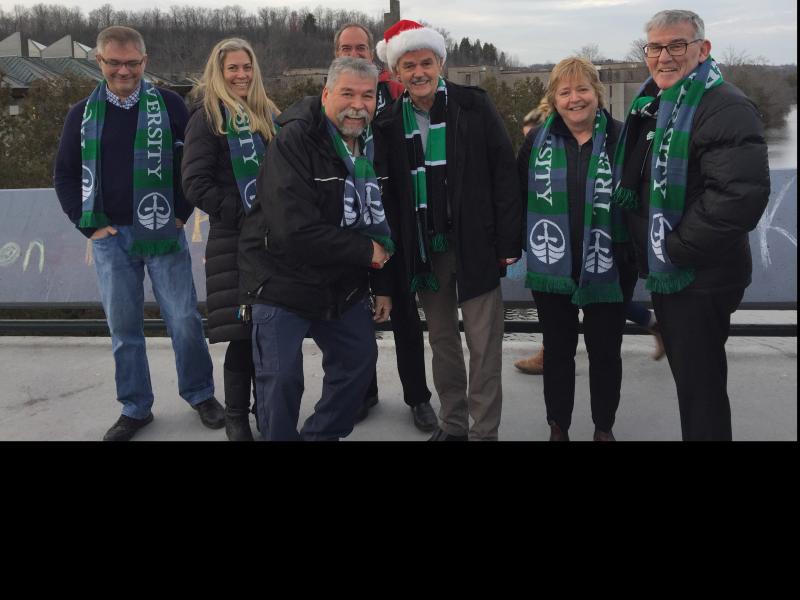 Dr. Leo Groarke with fellow staff members all wearing their Trent Scarves and taking part in the Trent holiday greeting video shoot on the Faryon Bridge.